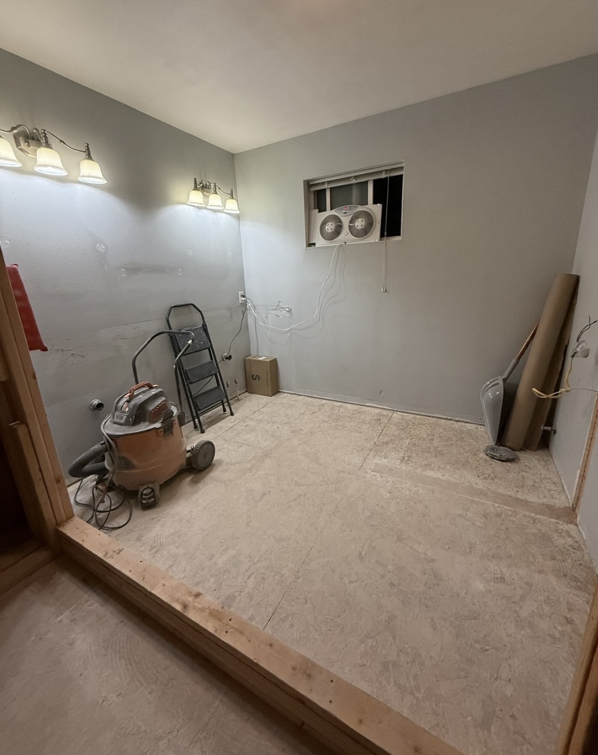 Bathroom after selective demolition — tile removed, subfloor exposed, walls cleared and ready for rebuild